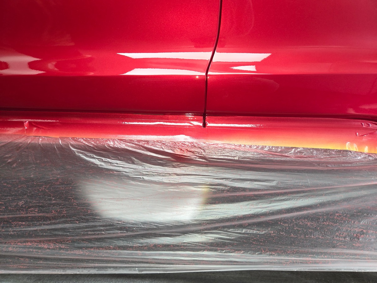 Red vehicle door repaired and repainted